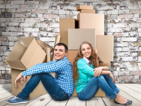 Professional movers handling furniture carefully in a Woolwich home relocation